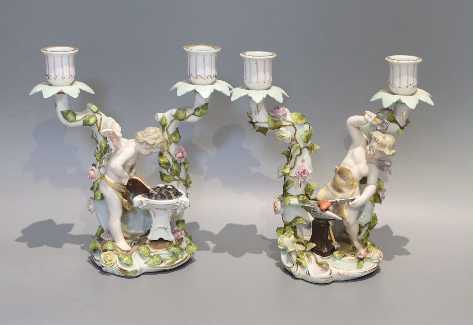 A pair of early 20th century German porcelain two branch candelabra, emblematic of industry, height 24cm